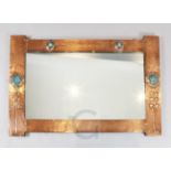 An Arts & Crafts planished copper overmantel, decorated with four blue Ruskin pottery Scottish