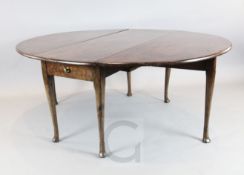 A George II red walnut drop leaf dining table, with oval top and dummy drawers to each end,