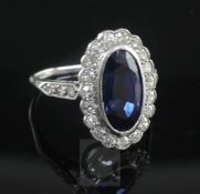 A 1940's/1950's synthetic sapphire and diamond oval cluster ring, with diamond set shoulders, size