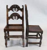 A set of twelve 17th century style Derbyshire oak dining chairs, with scroll carved backs, padded