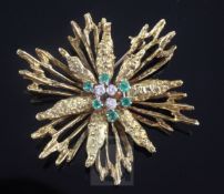 A 1970's 18ct gold, emerald and diamond set stylised starburst brooch, 5.5cm.