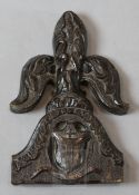A 16th century carved oak pew end finial, carved with a fleur de lys above an armorial, 10in.
