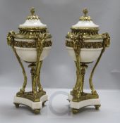 A pair of Louis XVI style white marble and gilt metal cassolettes, with rams mask headed supports,