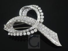 A French 18ct white gold and diamond scroll brooch set with graduated round and baguette cut