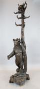 A Black Forest carved wood hallstand with a bear at the base, rear compartment and a bear cub in the