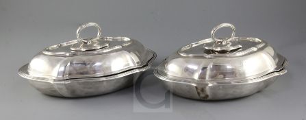 A pair of Edwardian silver shaped oval entreé dishes and covers with handles by Goldsmiths &