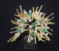 A 1970's 18ct gold, emerald and diamond set stylised flower head brooch, gross 21 grams, 58mm.