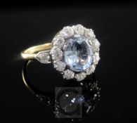A mid 20th century aquamarine and diamond oval cluster ring, size M.