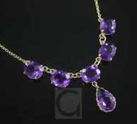 A 9ct gold and amethyst drop necklace, set with five round cut and one pear shaped amethysts, 46cm.