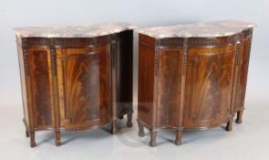 A near pair of 18th century style mahogany side cabinets, with pink marble tops and central bowed