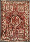 A Shirvan red ground rug, c.1890, with central medallion and corners with four geometric panels, 5ft