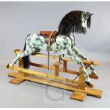 A dapple grey painted rocking horse, by Haddon Rockers, on pine trestle, H.4ft 2in. L.5ft 10in.