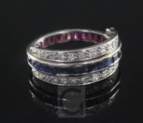 A mid 20th century platinum, sapphire, ruby and diamond triple band swivel ring, size M.