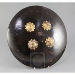 A fine Indian hide shield dhal, fitted with four gold kundun bosses set with gems, with silk knuckle