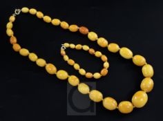 A single strand graduated oval amber bead necklace and similar bracelet, both with rolled gold