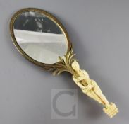 A 19th century French ormolu hand mirror, with ivory handle carved as an Egyptian attendant