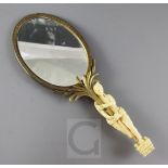 A 19th century French ormolu hand mirror, with ivory handle carved as an Egyptian attendant