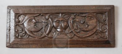 A 17th century oak panel, carved with three masks , 20.5 x 8in.