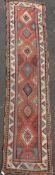 A Kazak red ground runner c.1850, with seven central hooked medallions and three row border, 13ft by