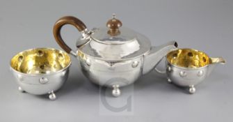 A George V Arts & Crafts silver three piece tea set by Albert Edward Jones, with raised stud