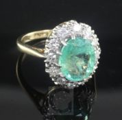 An 18ct gold, emerald and diamond oval cluster ring, the central oval cut emerald weighing 2.70cts