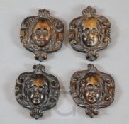 A set of four small 17th century carved walnut masks, within cartouche borders, each 4 x 3in.