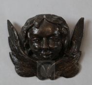 An early 16th century carved wood and painted gesso model of winged amorini bust, 5 x 6.25in.