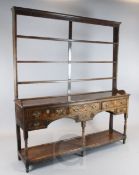 A George III oak dresser, with open three shelf rack, six drawers and pot board, W.5ft 10in. D.1ft