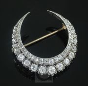 A Victorian gold, silver and diamond double crescent brooch, set with graduated round old cut