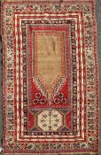 A Ghiordes red ground prayer rug, West Anatolia, with central mihrab and multi row border, 5ft 6in