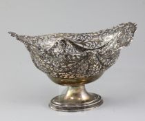 A George V pierced repousse silver oval pedestal fruit bowl, with foliated border and decorated with