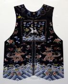 A Chinese black satin embroidered silk court jacket, Qing dynasty, woven with a silver pheasant rank
