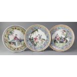 Three similar Chinese famille rose plates, mid 20th century, each painted with figures in a garden