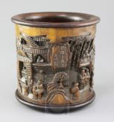 A Chinese bamboo brush pot, carved in high relief with figures amid pavilions with an inscription,
