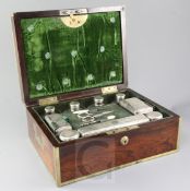 A George IV brass mounted rosewood travelling toilet box, fitted with nine silver mounted glass jars