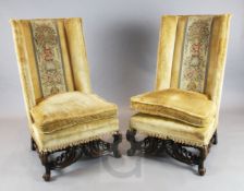 A pair of late 19th century Flemish walnut wingback chairs, with scrolling legs and stretchers, W.