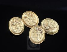 A pair of high carat gold oval cufflinks decorated in relief with cupids, gross 22.2 grams.