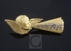 A late 19th century Tiffany & Co gold and enamel brooch, modelled as Cupid whistling musical notes