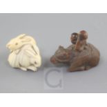 Two Japanese netsuke, 19th century, the first carved in ivory of two hares with horn or amber