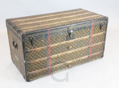 A Louis Vuitton travelling trunk, with brass mounts, wooded slats and LV fabric, interior with