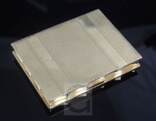A mid 20th century American Volupte 14ct gold rectangular compact, with reeded decoration, 79mm,