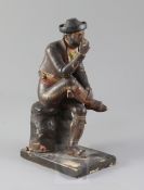 A 19th century Spanish polychrome painted terracotta figure of a seated gentleman smoking a pipe,