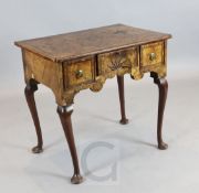 An early 18th century featherbanded walnut lowboy, with quarter veneered top and concave starburst