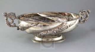 A late Victorian oval embossed silver pedestal bowl with twin scrolled caryatid handles, Elkington &