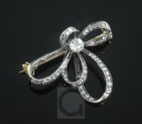 An Edwardian gold, silver and diamond scroll brooch, set with rose cut and single round cut