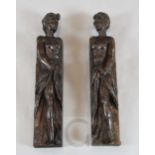 A pair of 17th century carved oak corbels, of caryatids holding drapery swags, 19.5in.