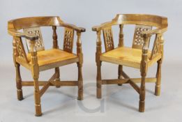 Robert 'Mouseman' Thompson. A pair of oak monks' armchairs, with lattice splats and pale tan leather