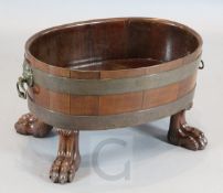 A George III brass bound mahogany oval wine cooler, with lion's mask handles and lion's paw feet,