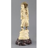 A Japanese walrus ivory okimono of a falconer, early 20th century, the figure standing on a rock,