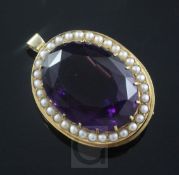 A gold mounted oval cut amethyst pendant brooch, with seed pearl set border, 34mm.